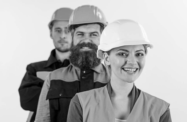 Woman and men in hard hats stand close as team. - Fotografie, Obrázek