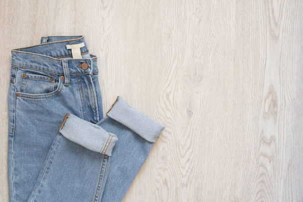 Blue jeans on a wooden background. Flat lay of female styled look. Top view. Shopping Concept. Fashion Outfits - 写真・画像