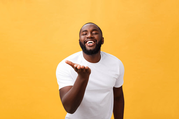 Joven hipster afroamericano asombrado usando una camiseta blanca cogida de la mano en un gesto sorprendido, manteniendo la boca abierta, mirando sorprendido
 - Foto, Imagen