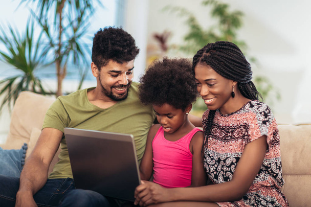Famiglia afroamericana che utilizza il computer portatile in soggiorno
. - Foto, immagini