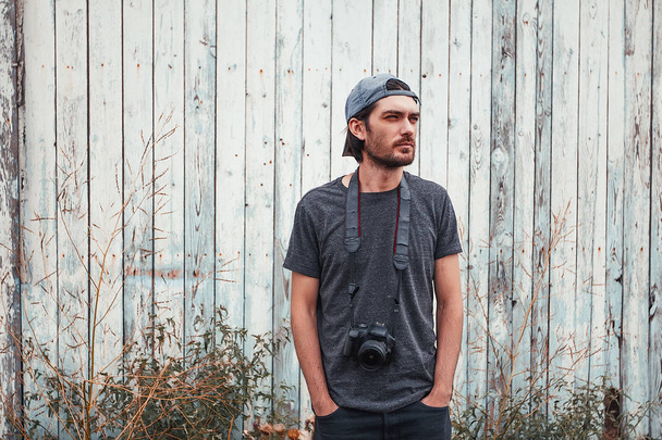 Portrait de jeune photographe masculin posant sur un vieux mur en bois
 - Photo, image
