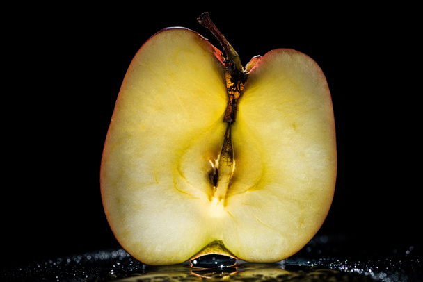half of ripe apple on black background - Photo, Image