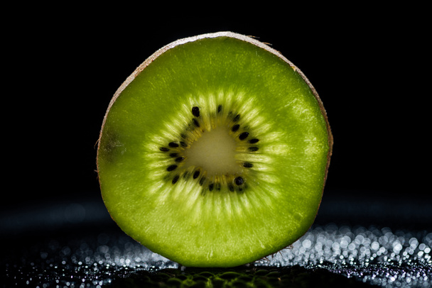 slice of fresh kiwi fruit on black background - Foto, Imagem