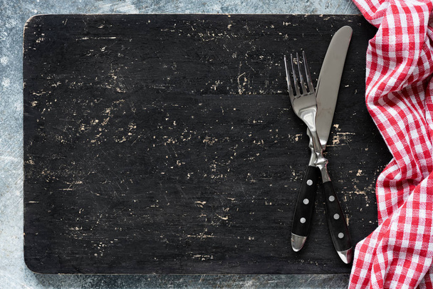 Blackboard or black cutting board and cutlery, food background with copy space for text. Web banner, design, menu concept - Foto, imagen