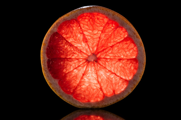 slice of fresh ripe grapefruit isolated on black - 写真・画像