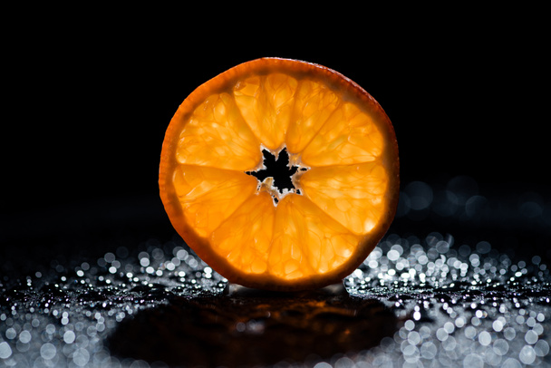 slice of fresh orange on black background with water drops - Foto, afbeelding