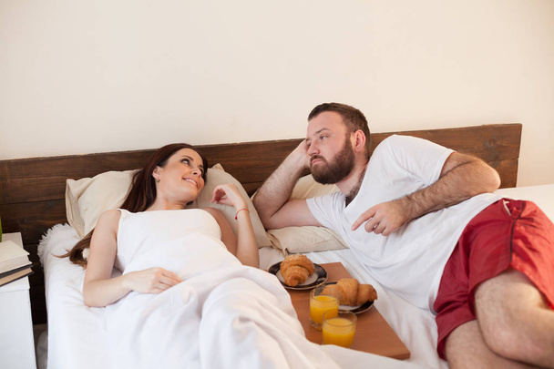 aviomies ja vaimo heräävät aamulla makuuhuoneessa viikonloppuna aamiainen sängyssä
 - Valokuva, kuva