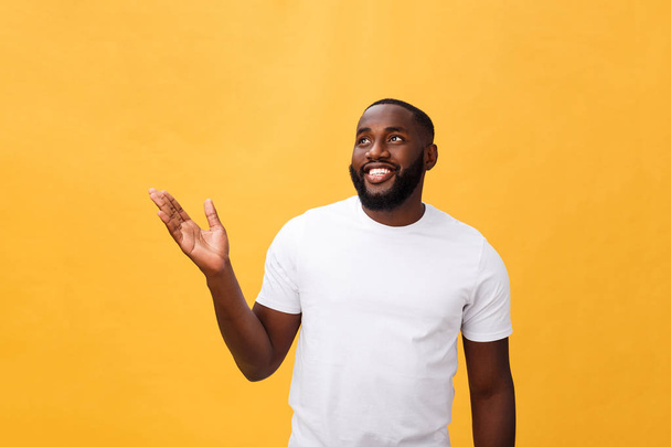 Afrikanisch-amerikanischer Mann mit Bart zeigt Hand weg Seite isoliert über gelbem Hintergrund - Foto, Bild