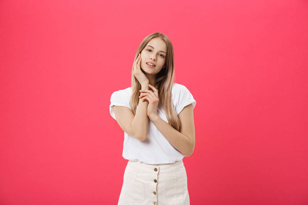 Attractive young girl touching her face. Photo of blonde girl with perfect skin on pink background. Beauty and Skin care concept - Foto, afbeelding