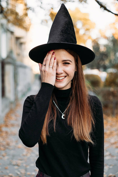 Halloween Witch in autumn city.Halloween mysterious lady in woods. - Fotoğraf, Görsel