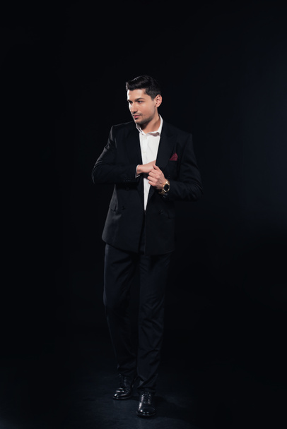 handsome man posing in suit isolated on black - Foto, Imagem