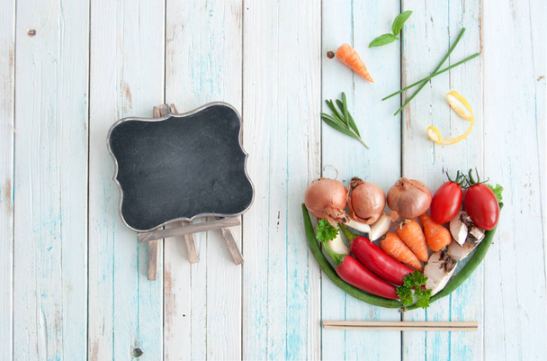 Natural ingredients in the shape of a soup bowl with empty chalkboard  - Fotoğraf, Görsel