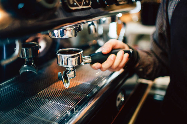 Kuva nuoresta miehestä pitämässä cezveä yhdessä kädessä kahvi kädessään. Hän keittää kahvia.
. - Valokuva, kuva