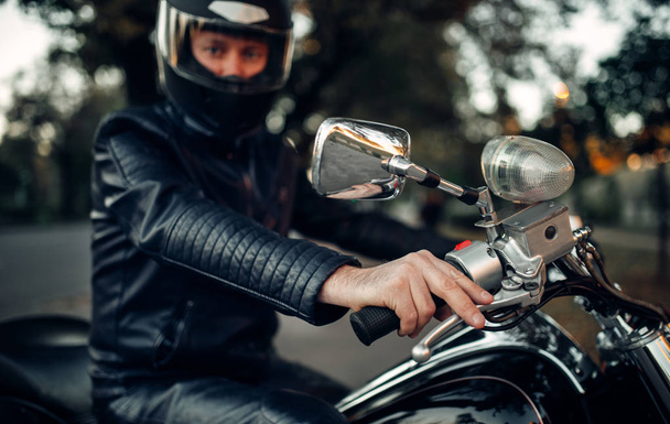 Motociclista en casco posa en una motocicleta, helicóptero clásico. Bicicleta vintage, jinete y su amigo de dos ruedas, estilo de vida de libertad, ciclismo
 - Foto, Imagen