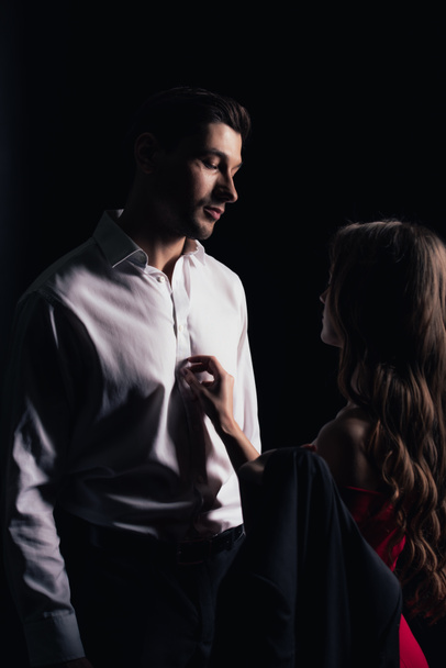 woman gently touching handsome man isolated on black - Foto, afbeelding