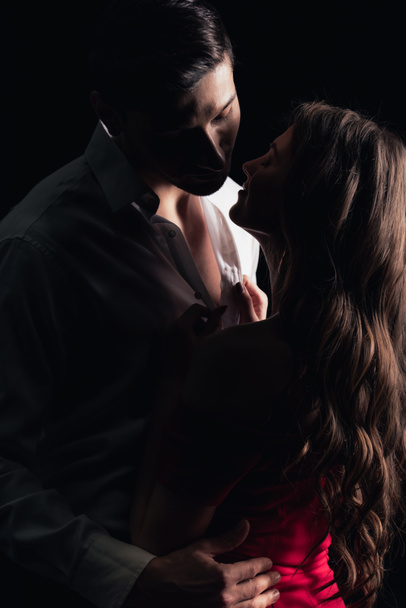 romantic couple embracing and touching each other isolated on black - Photo, Image