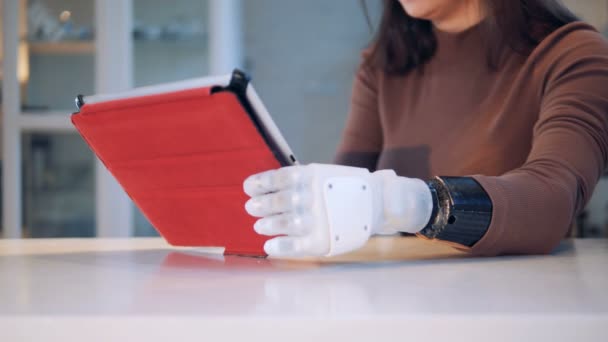 Woman holds a tablet with robotic hand, close up. - Felvétel, videó