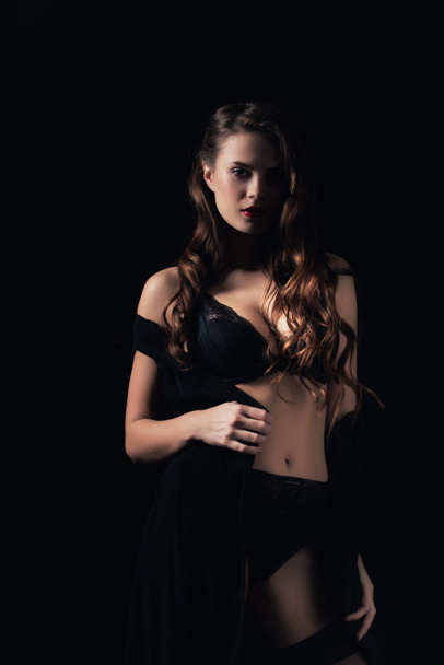 seductive woman looking at camera and posing in lingerie isolated on black - Fotografie, Obrázek
