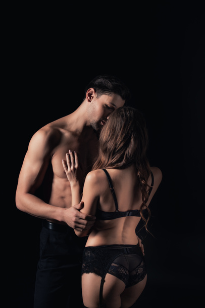 pareja desnuda abrazos y besos aislados en negro
 - Foto, Imagen