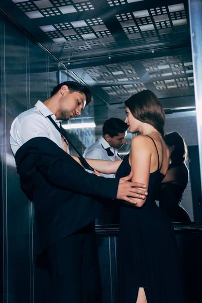 beautiful couple passionately touching each other in elevator - Photo, Image