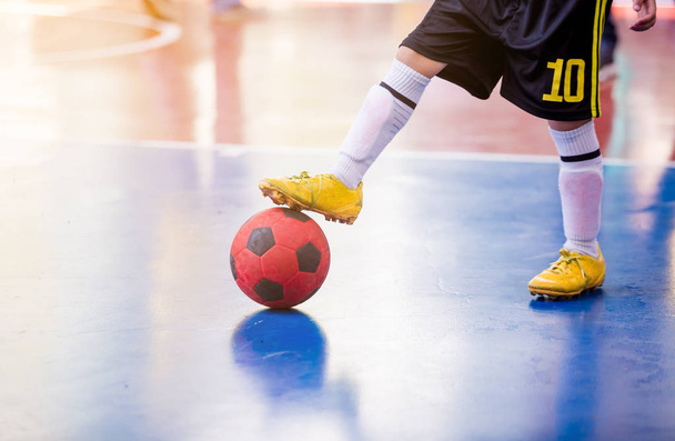 Kinder-Futsal-Spieler fangen und kontrollieren den Ball, um ins Tor zu schießen. Fußballer bekämpfen sich, indem sie gegen den Ball treten. Fußballhallensporthalle. Futsalspieler, Ball - Foto, Bild