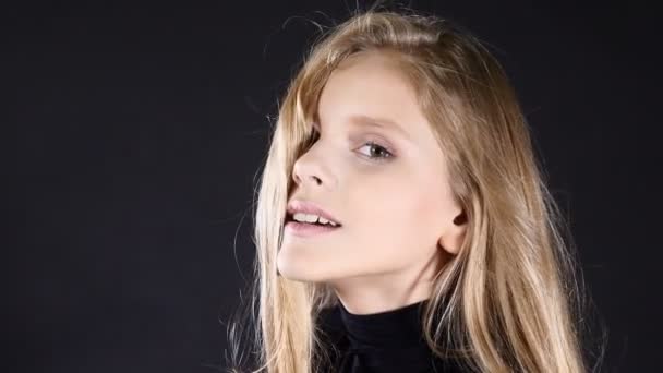 Little teenaged model blowing kiss . Video portrait isolated on black. - Footage, Video