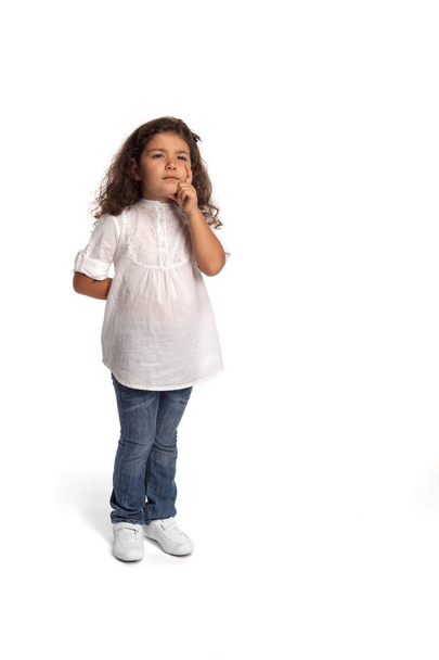 Full length portrait of a little girl thinking on white background - Photo, Image