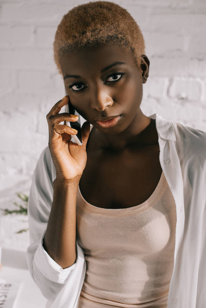 close up of african american woman with short hair talking on smartphone - Foto, imagen