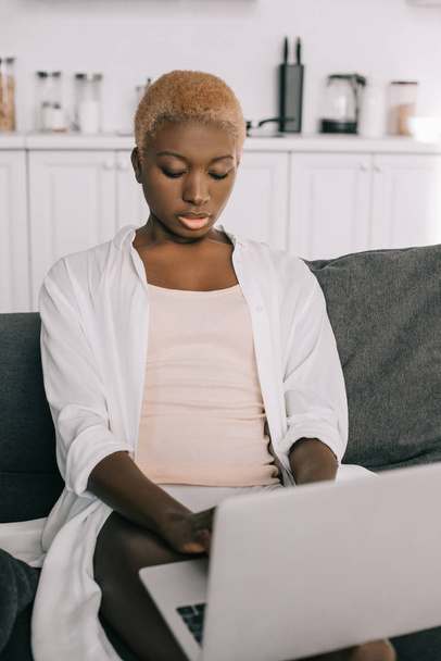 concentrated african american woman typing on laptop in living room  - Photo, Image