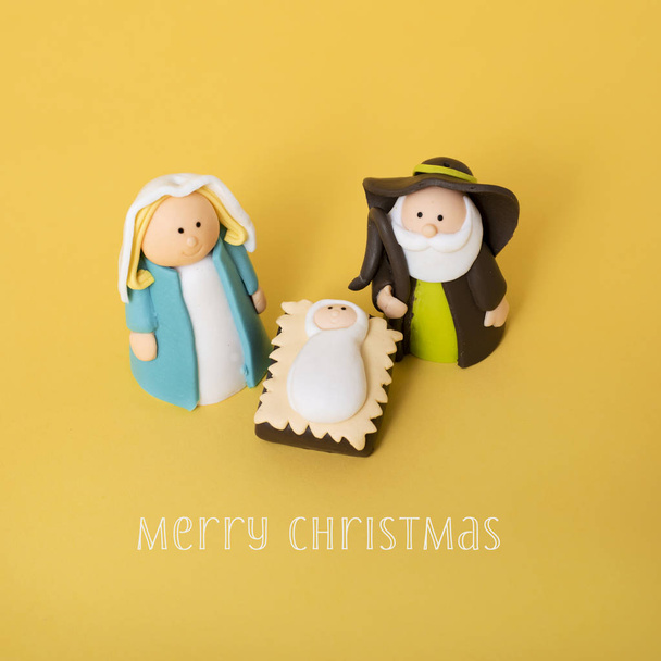 la sagrada familia, el niño Jesús, la Virgen María y San José, y el texto feliz Navidad sobre un fondo naranja colorido
 - Foto, Imagen