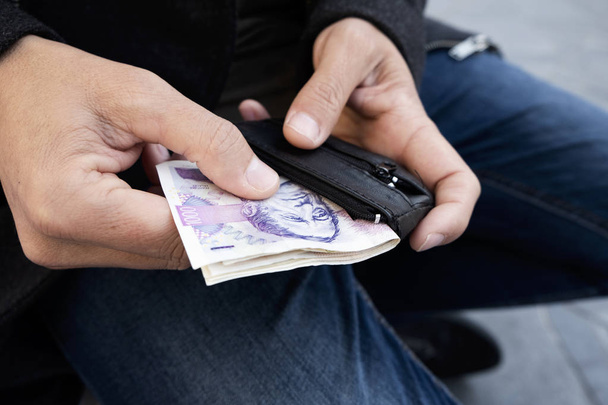 bir genç beyaz adama koyarak ya da bazı Çek korunası banknotlar onun cüzdanından kapalı alarak sokakta closeup - Fotoğraf, Görsel