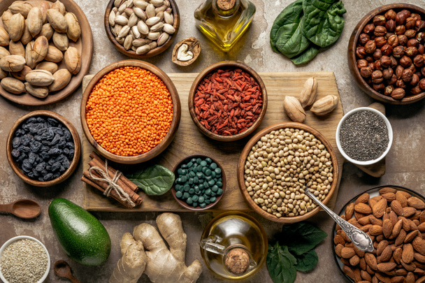 flat lay of legumes, superfoods and healthy ingredients on wooden board with rustic background - Photo, Image
