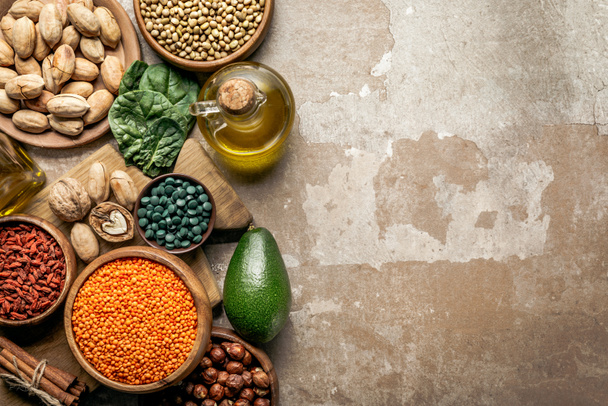 Ansicht von Superfoods, Hülsenfrüchten, Olivenöl und gesunden Zutaten auf rustikalem Hintergrund mit Kopierraum - Foto, Bild