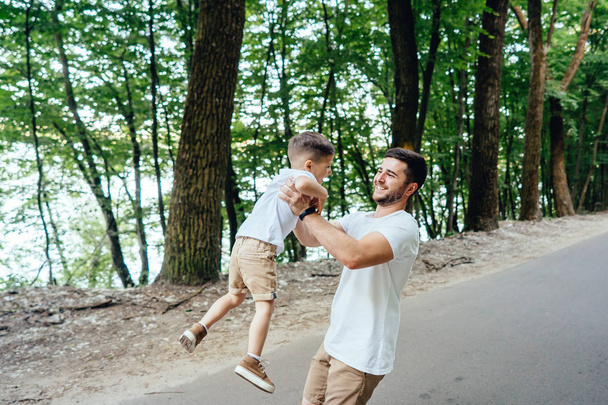 Щасливий батько кружляє на руках свого молодого сина
. - Фото, зображення