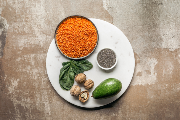 sementes de chia, abacate, lentilhas vermelhas e nozes na placa com fundo rústico texturizado
 - Foto, Imagem