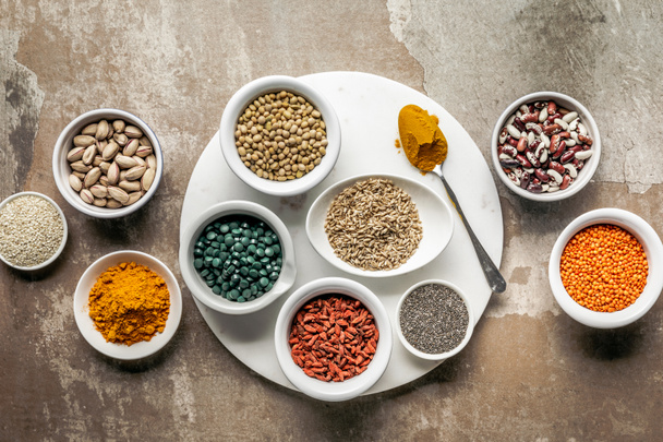top view of superfoods, nuts and legumes on textured rustic background - Photo, Image