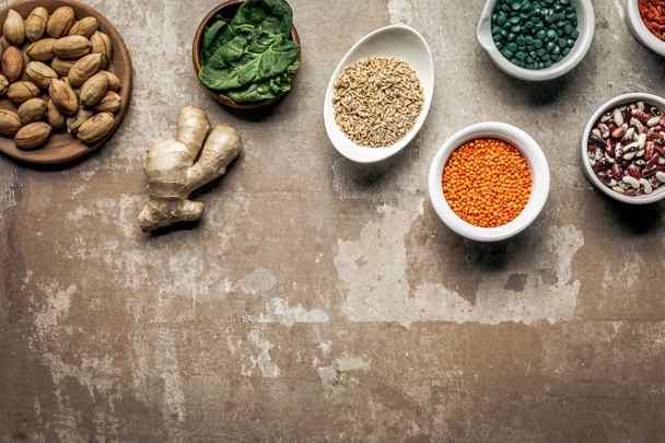 top view of legumes, ginger and spinach on textured rustic background with copy space - Photo, Image