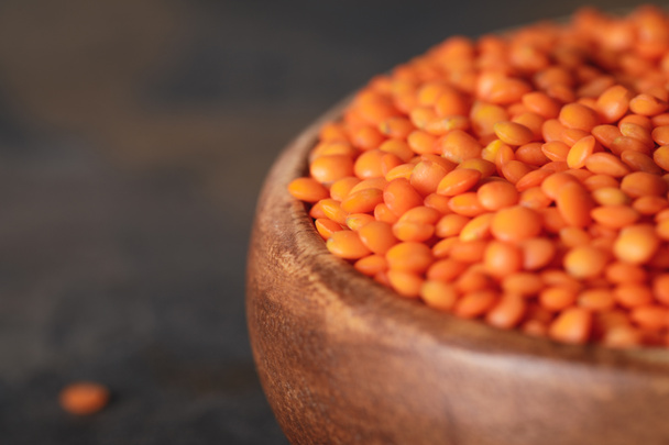 selective focus of red lentils in wooden bowl with copy space - Photo, Image