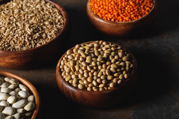 soybean, lentils and oat groats in wooden bowls on table - Photo, Image