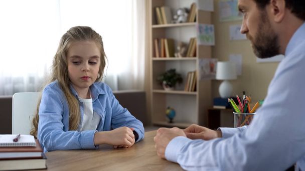 Little girl is angry with her father, ignoring him, family conflict, parenting - 写真・画像