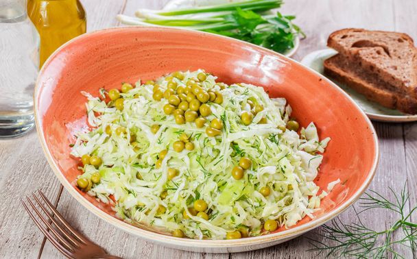 Salade fraîche avec chou, pois verts, oignons et légumes verts sur fond bois fermer. Nourriture saine, végétalien. Vue du dessus
 - Photo, image
