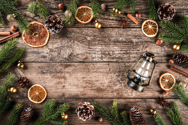 Fond en bois de Noël avec branches de sapin, lampe, cônes de pin, décoration dorée. Thème Noël et Nouvel An, bokeh, neige. Couché plat, vue du dessus
 - Photo, image