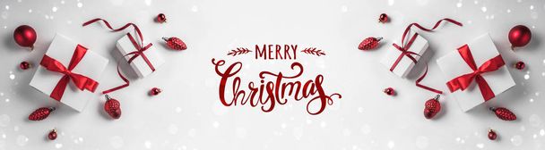 Joyeux Noël Typographique sur fond blanc avec des boîtes-cadeaux et une décoration rouge. Carte de Noël et Nouvel An, bokeh, lumière. Couchage plat, vue sur le dessus, large composition
 - Photo, image