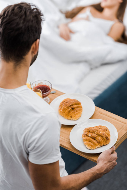 selective focus of man holding wooden tray with tasty breakfast - Valokuva, kuva