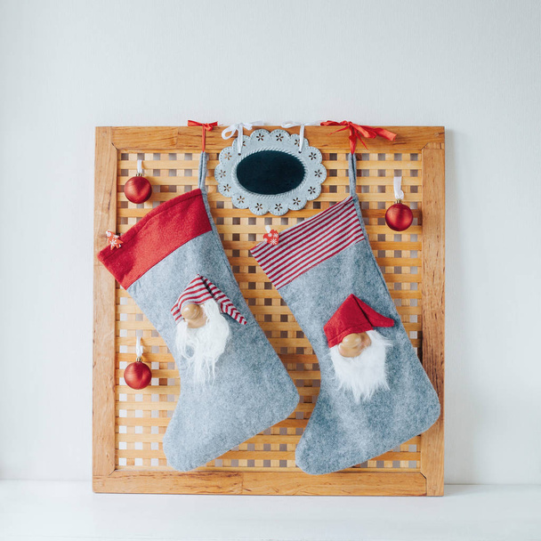 christmas socks hanging on wooden board with decorations - Фото, изображение