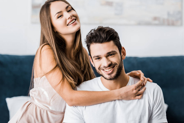 young happy woman hugging boyfriend and smiling - Zdjęcie, obraz