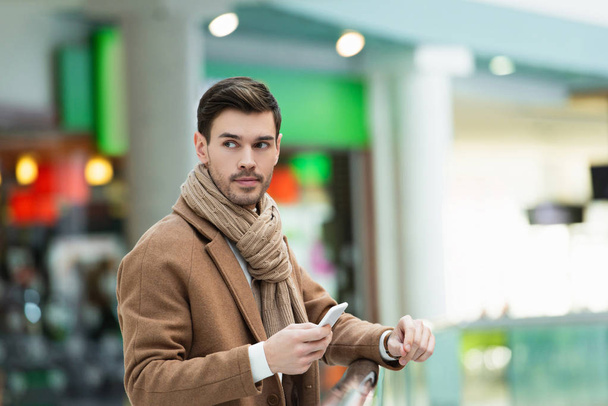 homem bonito com smartphone no shopping
 - Foto, Imagem