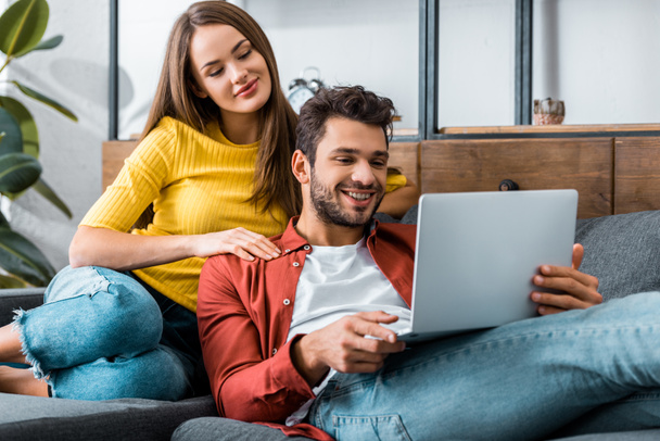 young couple looking at laptop in living room - Foto, imagen
