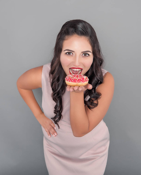 Beautiful happy plus size woman with donut. Body positive concept - Фото, изображение