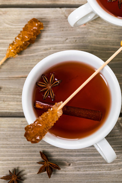 Őszi-téli forró fűszeres tea, fahéj, ánizs, méz, egy fából készült háttér, felülnézet csésze. Szelektív összpontosít. - Fotó, kép